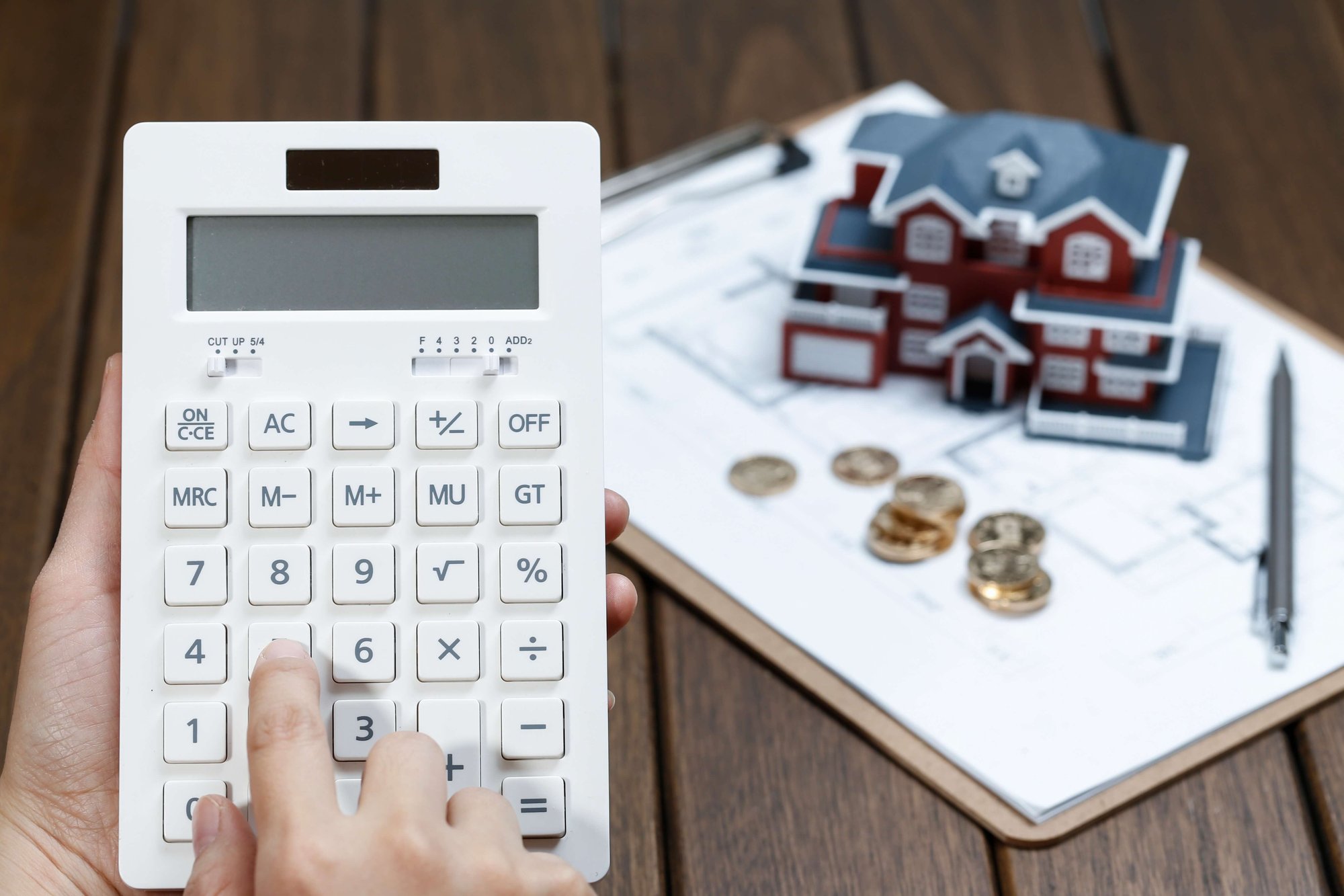 female-hand-operating-calculator-front-villa-house-model (1)